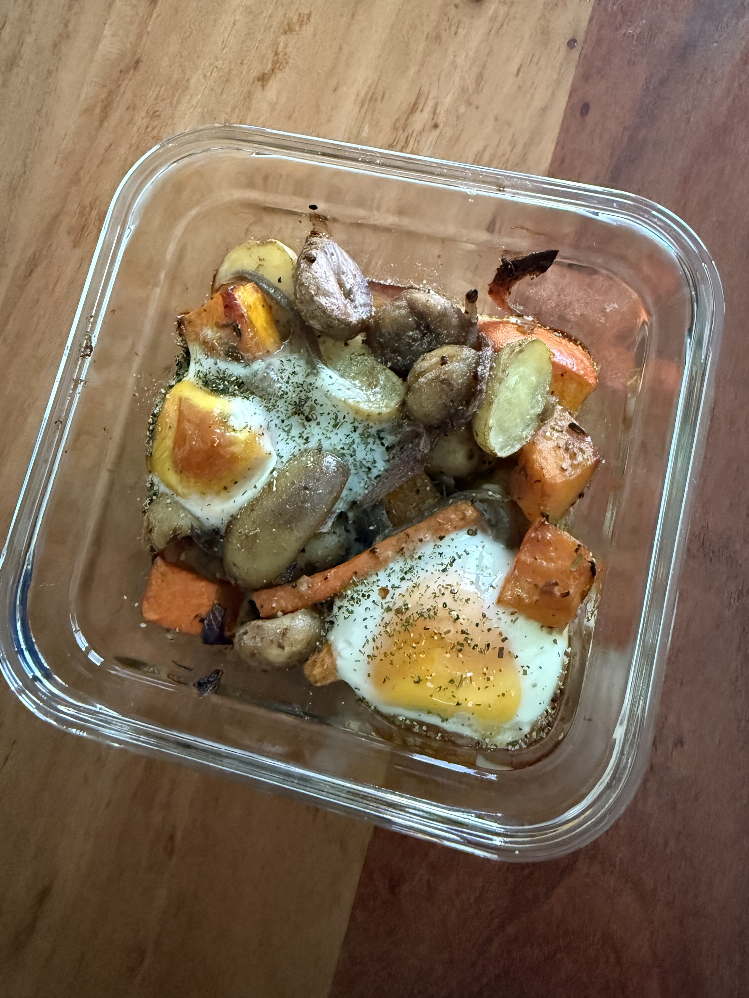 Ofengemüse mit Marroni, Kürbis, Kartoffeln und Karotten in einem Glasbehälter, mit frischem Ei darüber gebacken – perfekt als Mealprep-Portion.