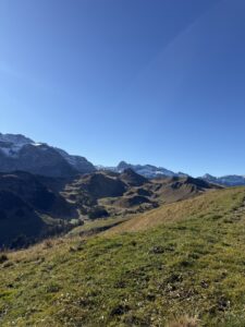 Aussicht auf das weite Alpgelände – herbstliche Wiesen, klare Sicht und imposante Bergkulisse.