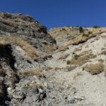 Graue Felsformation mit Geröllhang – eindrucksvolle Gesteinsschichten entlang des Wanderwegs durch die alpine Landschaft.