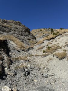 Graue Felsformation mit Geröllhang – eindrucksvolle Gesteinsschichten entlang des Wanderwegs durch die alpine Landschaft.