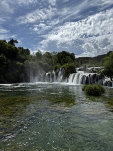 Die berühmten Skradinski Buk Wasserfälle im Krka-Nationalpark mit klarer Wasseroberfläche und bewölktem Himmel.