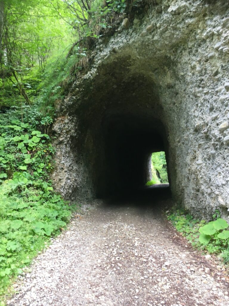 Eingang des Hegenloch-Tunnels, einem alten, von Hand in den Fels gehauenen Durchgang mitten im Grünen.