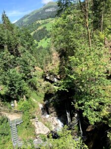 Blick über die Cholerenschlucht Adelboden auf grüne Hänge und Wälder im Berner Oberland.