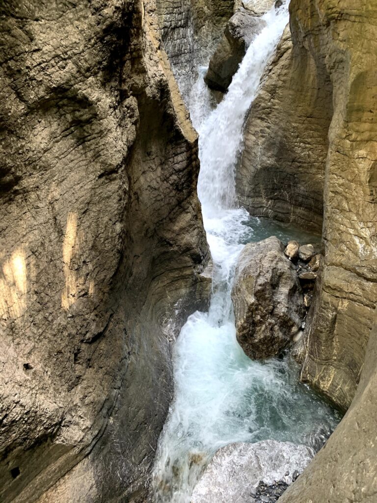 Wasserfall in der Cholerenschlucht Adelboden, umgeben von glatten, hellen Felswänden.