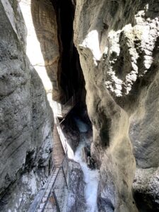 Schmaler Steg mit Geländer zwischen den hohen Felsen der Cholerenschlucht in Adelboden.