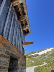 Holzbergshütte mit Wegweisern Richtung Axalp und Oberberg entlang des Wanderwegs Grindelwald First–Axalp.