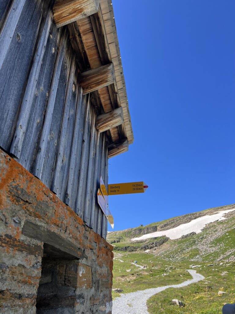 Holzbergshütte mit Wegweisern Richtung Axalp und Oberberg entlang des Wanderwegs Grindelwald First–Axalp.