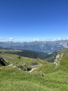 Blick über die grünen Hänge und Bergseen zwischen Grindelwald First und Axalp mit Weitblick ins Berner Oberland.