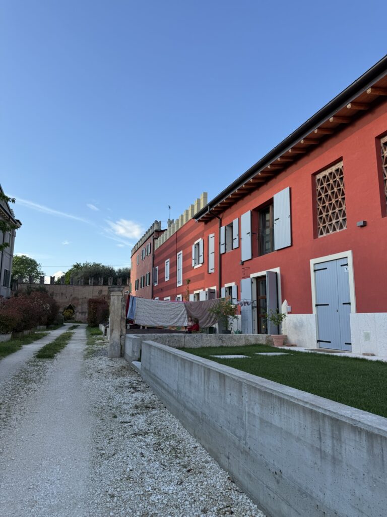 Rote Ferienhäuser mit Fensterläden in Italien entlang eines ruhigen Weges – hundefreundliche Airbnb-Anlage mit viel Platz im Aussenbereich