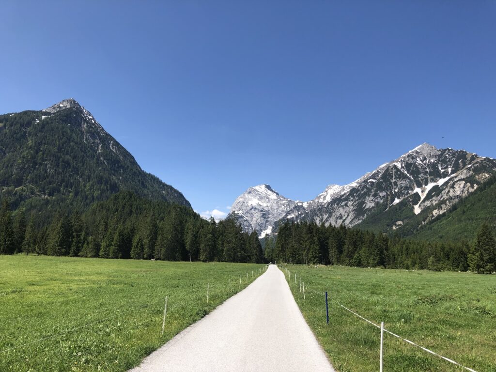 Breiter Wanderweg durch Wiesen bei Pertisau mit Blick auf die Karwendelberge – einfache Wanderung in Tirol.