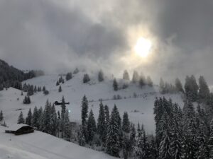 Winterliche Stimmung auf dem Springenboden mit Nebel, Schneefall und Sonne über verschneiten Hängen