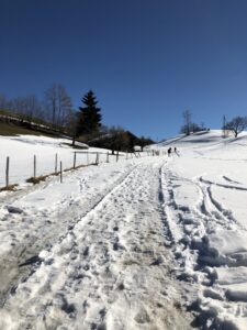 Präparierter Winterwanderweg in Aeschiried mit Fussstapfen im Schnee und weiter Aussicht
