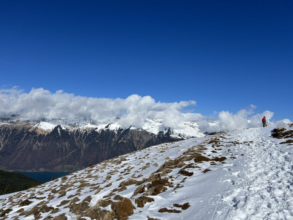 Winterwanderweg auf der Axalp mit Blick auf die Berge und den Brienzersee im Hintergrund