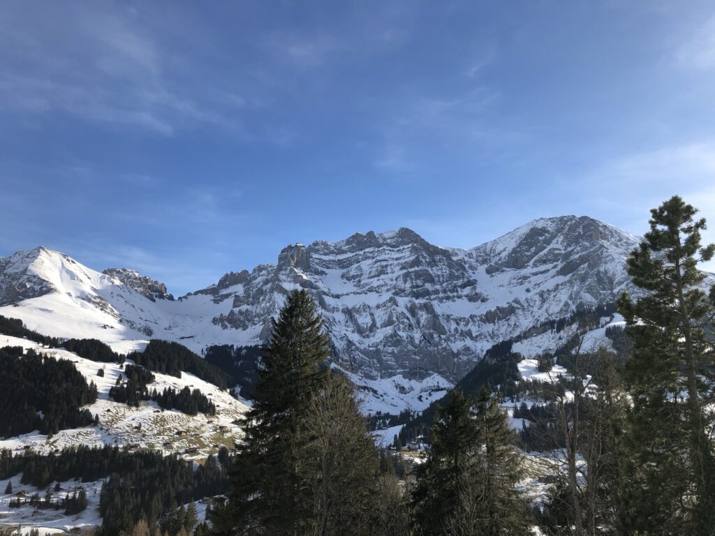 Alp mit verschneiter Wiese und Bergkulisse auf dem Hörelirundweg bei Adelboden