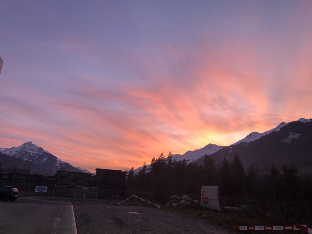 Abendstimmung bei Adelboden mit farbigem Winterhimmel und Silhouetten der Berge