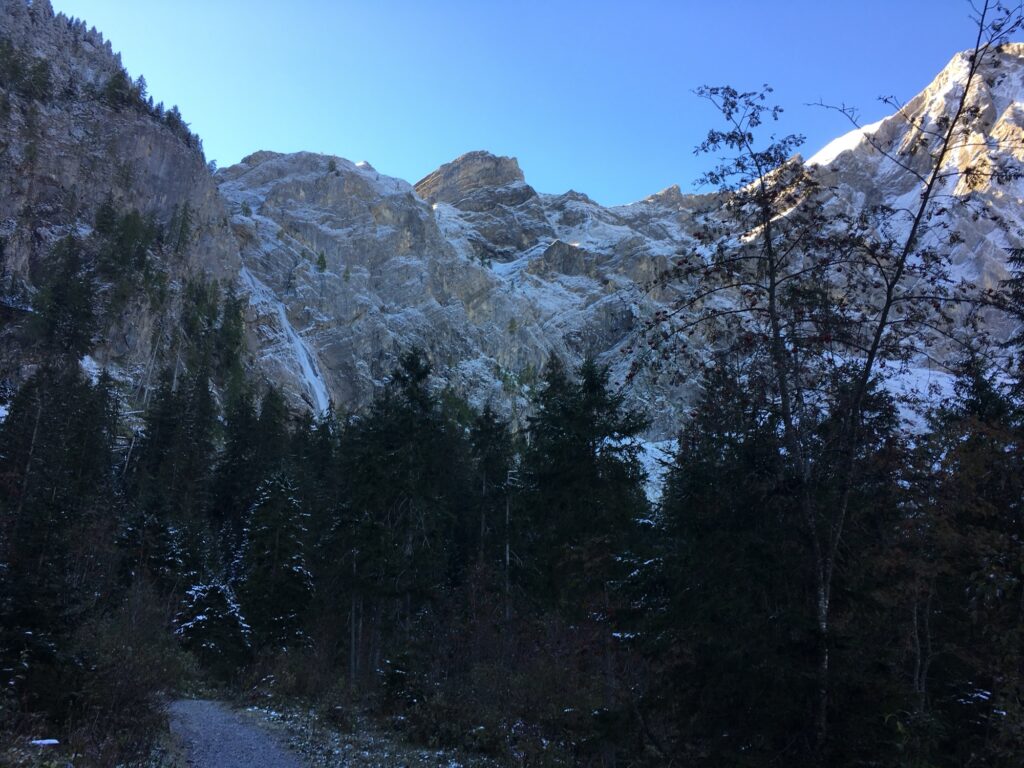 Winterlicher Wanderweg bei Adelboden mit Blick auf schroffe Felswände und verschneite Berge