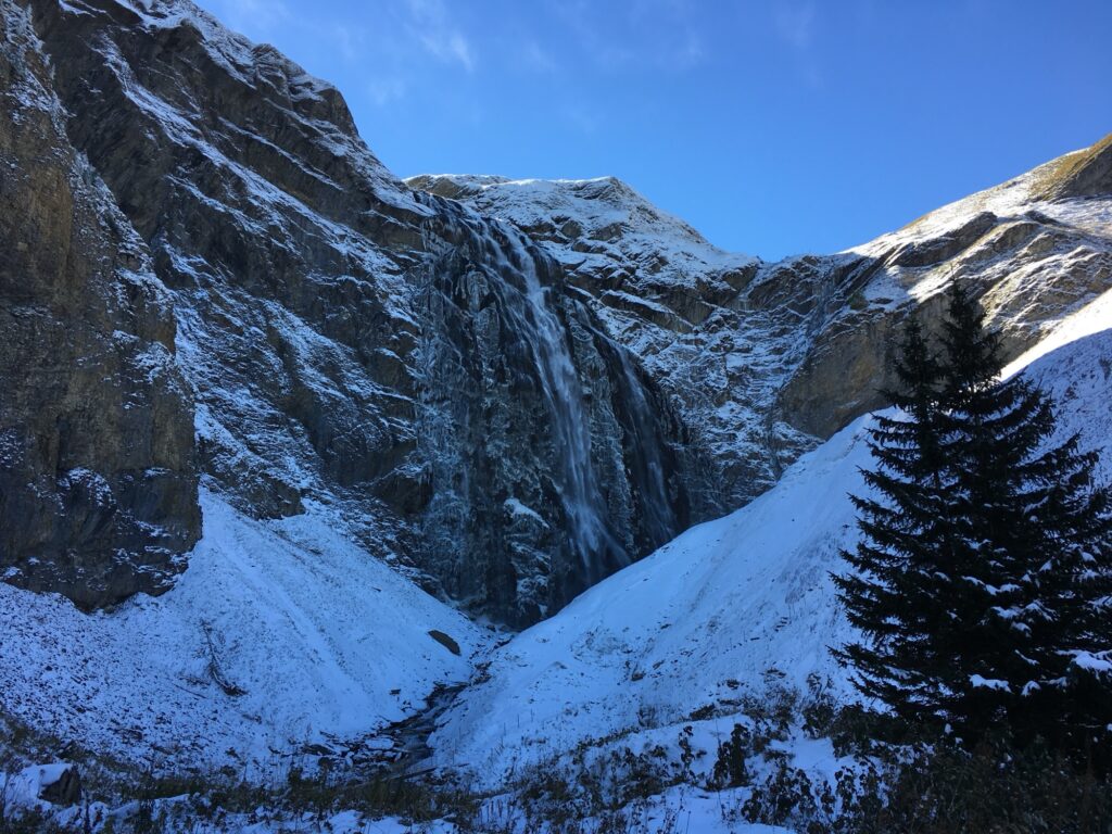 Engstligenfall im Winter bei Adelboden, umgeben von Schnee und steilen Felsflanken