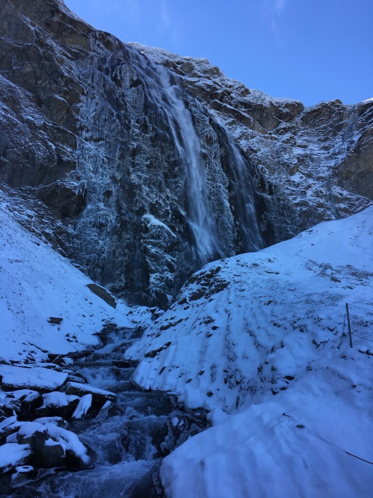Gefrorener Engstligenfall bei Adelboden mit Eisformationen und Schnee entlang des Wanderwegs
