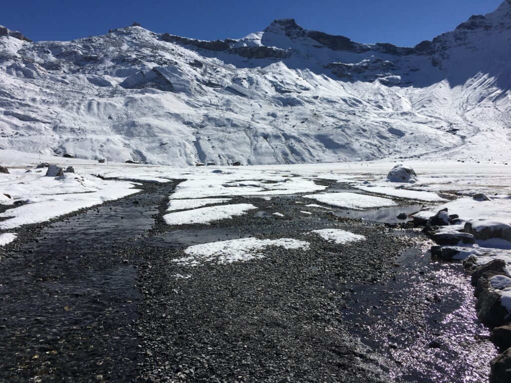 Verschneite Engstligenalp mit Bach, Alphütten und imposanter Bergkulisse bei Adelboden