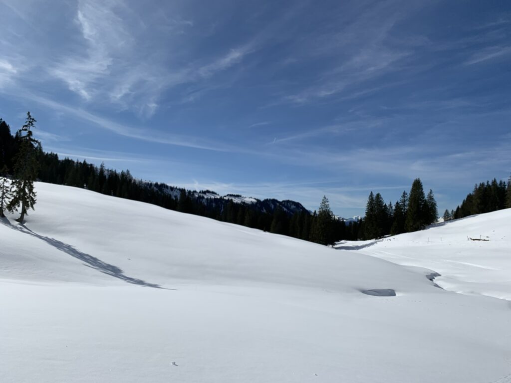 Weite Schneefläche auf der Lombachalp mit Blick auf das Berner Oberland
