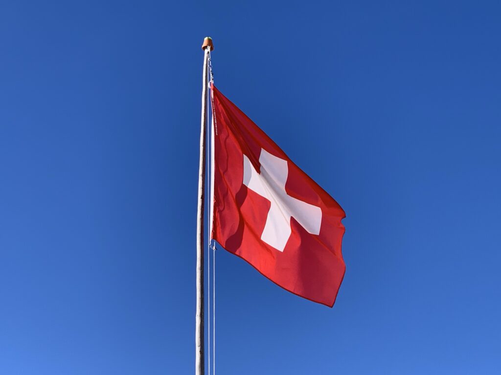 Schweizer Fahne auf der Lombachalp vor blauem Winterhimmel