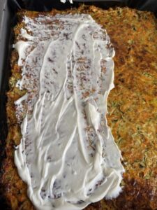 Zucchini-Karotten-Boden frisch aus dem Ofen, bestrichen mit cremigem Frischkäse als Basis für einen gesunden Gemüse-Wrap