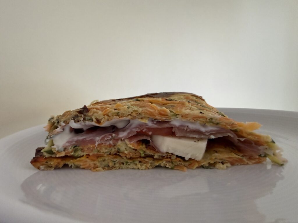 Angeschnittener Zucchini-Wrap mit Frischkäse, Rohschinken und Mozzarella, saftig gefüllt und serviert als Low-Carb-Mahlzeit ohne Mehl