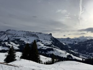 Sonnenlicht über verschneiten Bergen bei der Winterwanderung auf der Marbachegg im Entlebuch