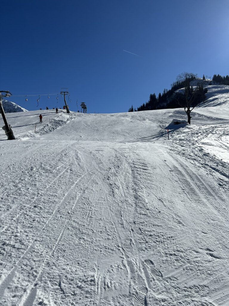 Präparierter Winterweg im Skigebiet auf der Grimmialp im Diemtigtal bei blauem Himmel