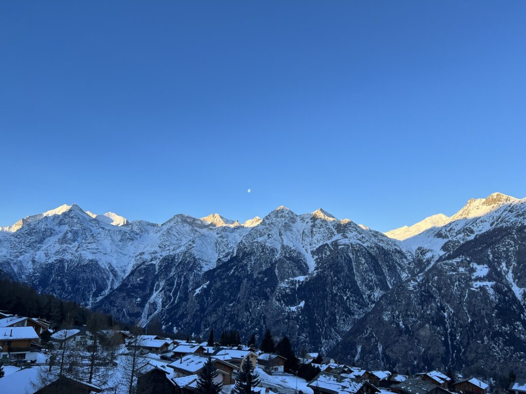 Winterwanderweg bei der Hannigalp in Grächen mit Wegweiser und tiefblauem Himmel.