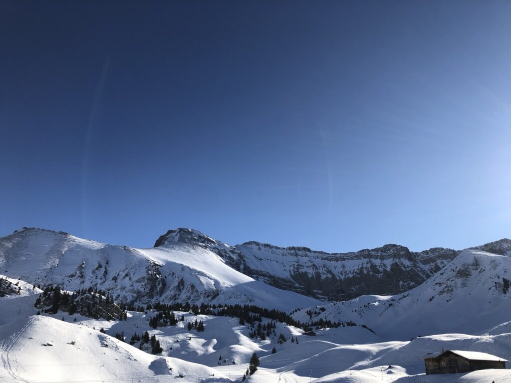 Sonniges Winterpanorama auf der Elsigen-Metsch mit verschneiten Gipfeln und blauem Himmel