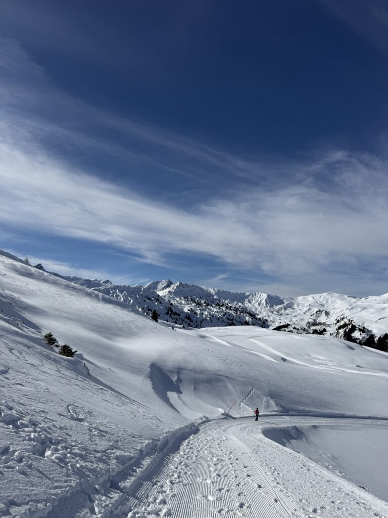 Präparierter Winterwanderweg am Betelberg bei der Lenk mit geschwungenen Spuren durch die verschneite Hügellandschaft.