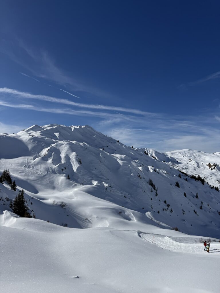 Winterlandschaft am Betelberg mit tief verschneiten Hängen und Wanderern auf dem Winterwanderweg.