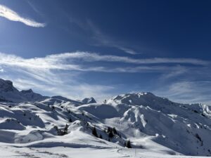 Weite Schneehänge am Betelberg im Berner Oberland mit geschwungenem Winterwanderweg durch die Hügellandschaft.