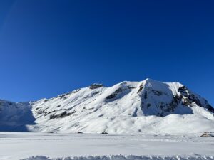 Sonnige Winterlandschaft der Engstligenalp mit flacher Hochebene und verschneiten Gipfeln