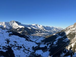 Panoramablick ins Tal von Adelboden mit verschneiten Bergen und Winterlandschaft aus der Höhe