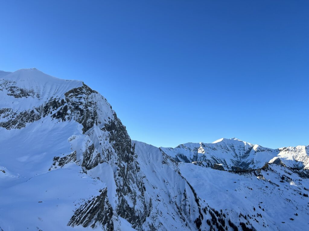 Steile verschneite Bergflanken rund um die Engstligenalp unter klarem Himmel