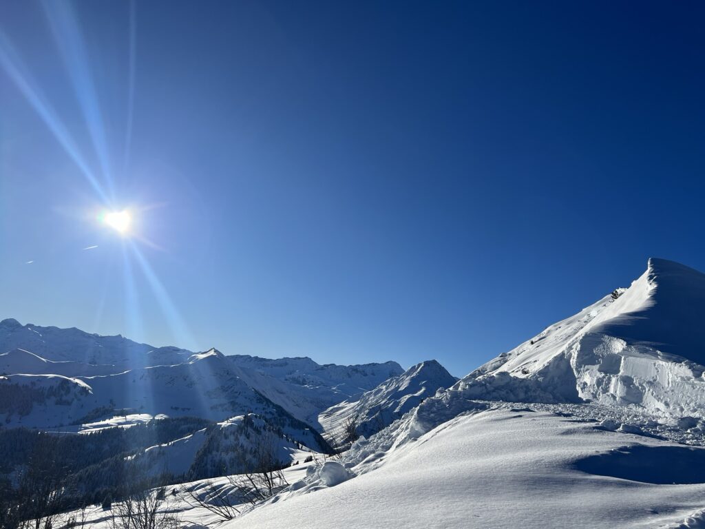 Sonnige Winterlandschaft am Rinderberg mit verschneiten Gipfeln und klarer Fernsicht