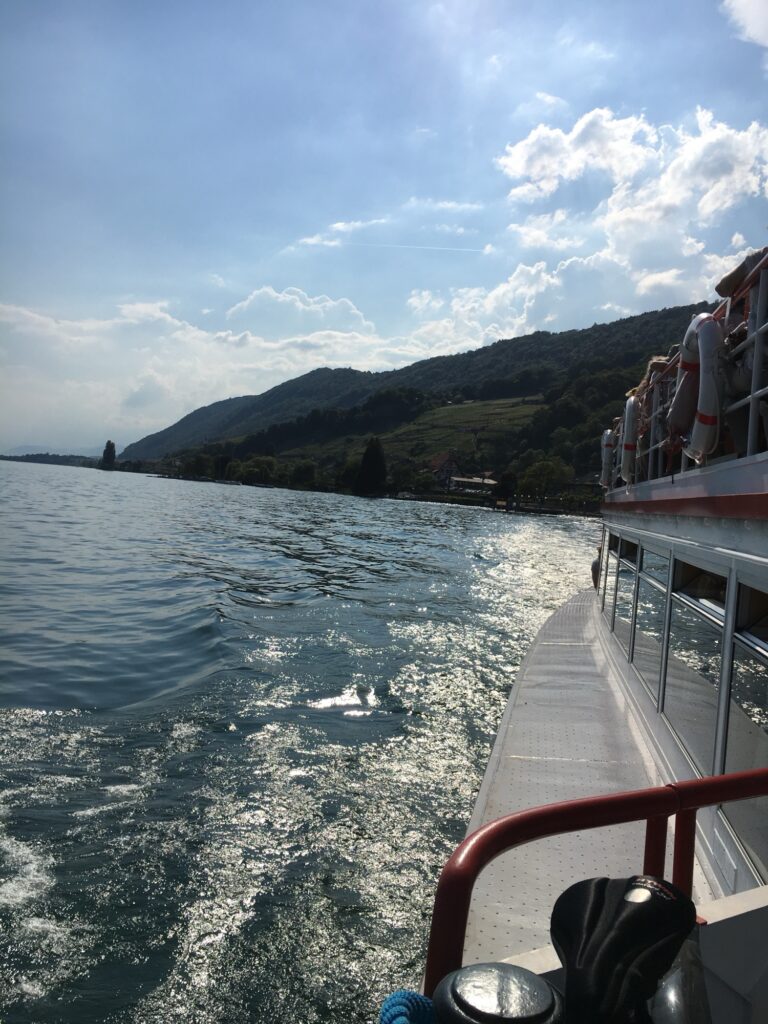 Schifffahrt auf dem Bielersee mit Blick entlang des Bootes und Uferlandschaft bei Twann