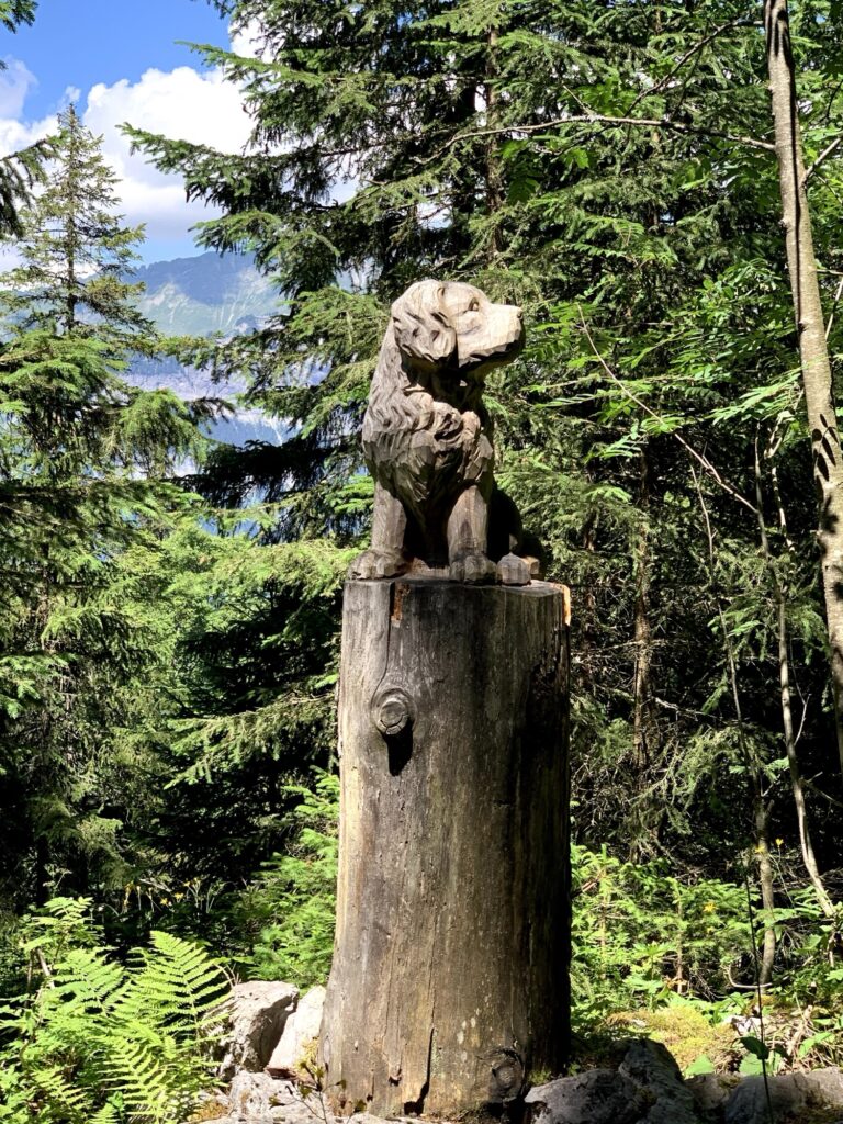 Holzschnitzerei Hund auf dem Schnitzlerweg Axalp im Berner Oberland 