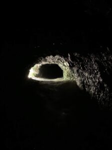 Dunkle Höhle am Glütschbach bei Thun mit Licht am Ausgang und natürlichem Tunnel