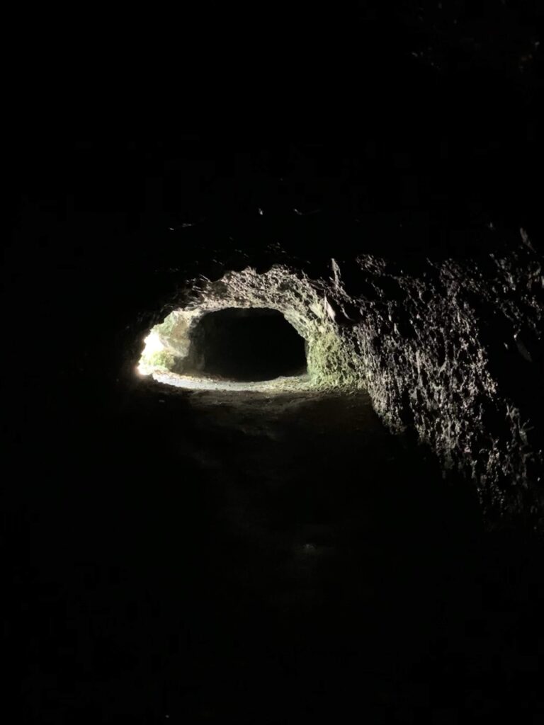 Dunkle Höhle am Glütschbach bei Thun mit Licht am Ausgang und natürlichem Tunnel