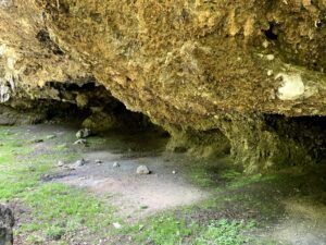 Grosse Felsgrotte am Glütschbach bei Thun mit erdigem Boden und moosigen Steinen