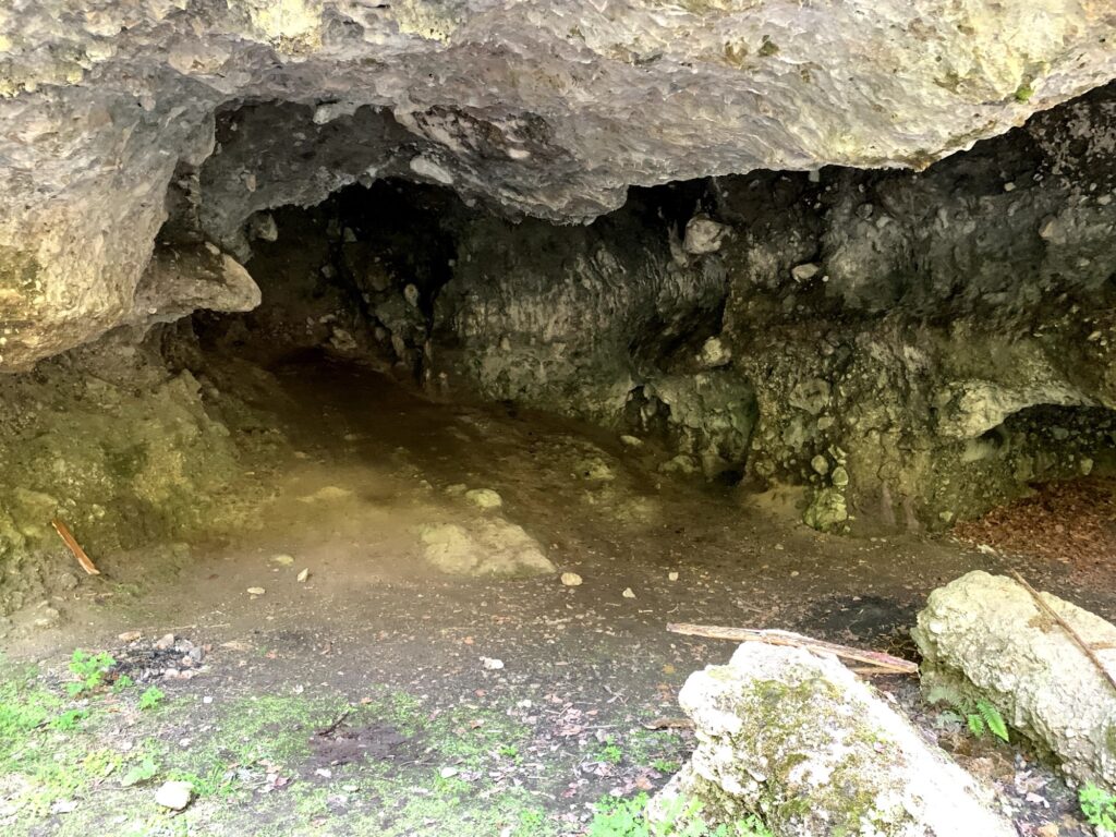 Höhle am Glütschbach bei Thun mit feuchtem Fels und kleiner Wasserstelle im Inneren