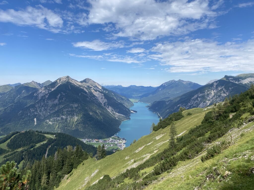 Panoramablick über Achensee und umliegende Berge bei sonnigem Sommerwetter während einer Wanderung