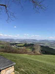 Wanderweg auf dem Belpberg mit Blick auf die Alpen und weite Wiesenlandschaft