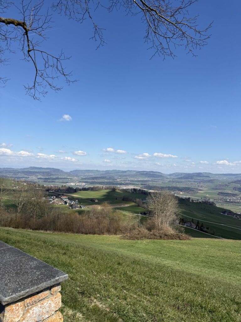 Wanderweg auf dem Belpberg mit Blick auf die Alpen und weite Wiesenlandschaft