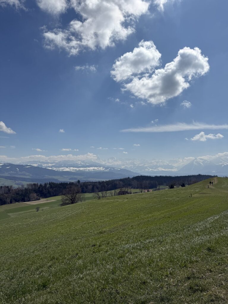 Frühlingslandschaft auf dem Belpberg mit Aussicht über Hügel und Dörfer bei Bern
