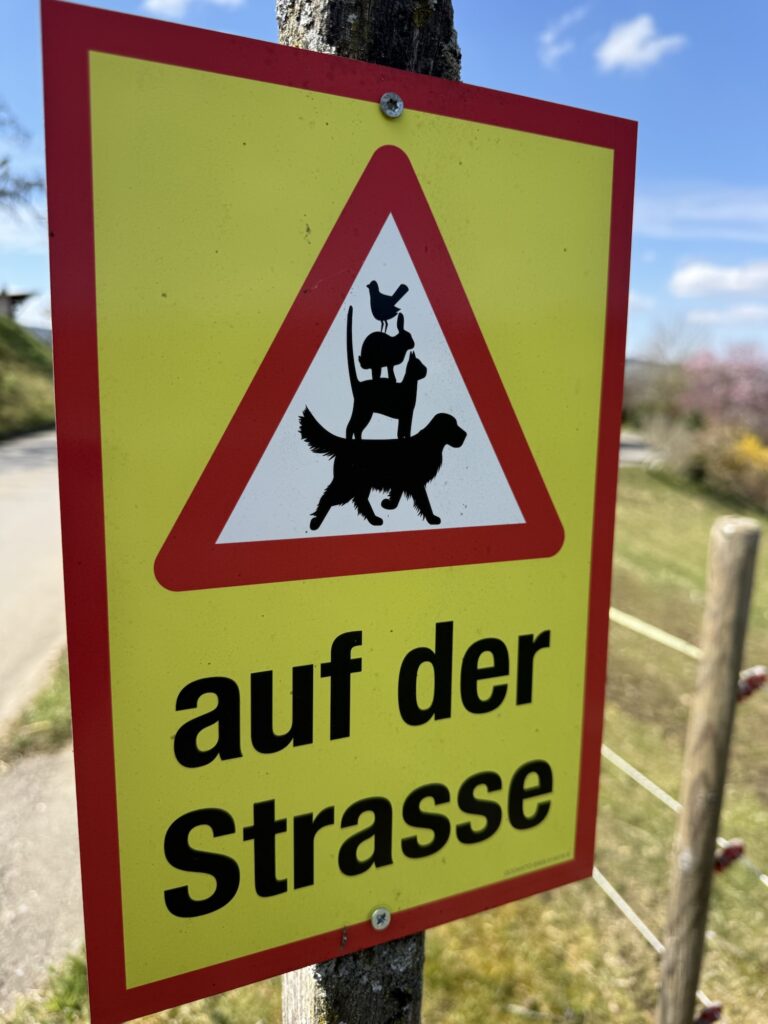 Lustiges Warnschild auf dem Belpberg mit Bremer-Stadtmusikanten-Motiv an der Strasse