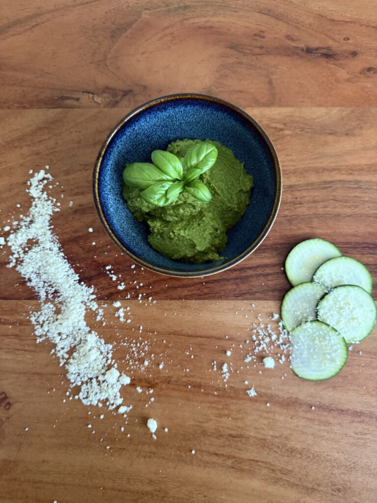 Basilikum-Zucchini-Pesto mit frischem Basilikum, Zucchinischeiben und Parmesan